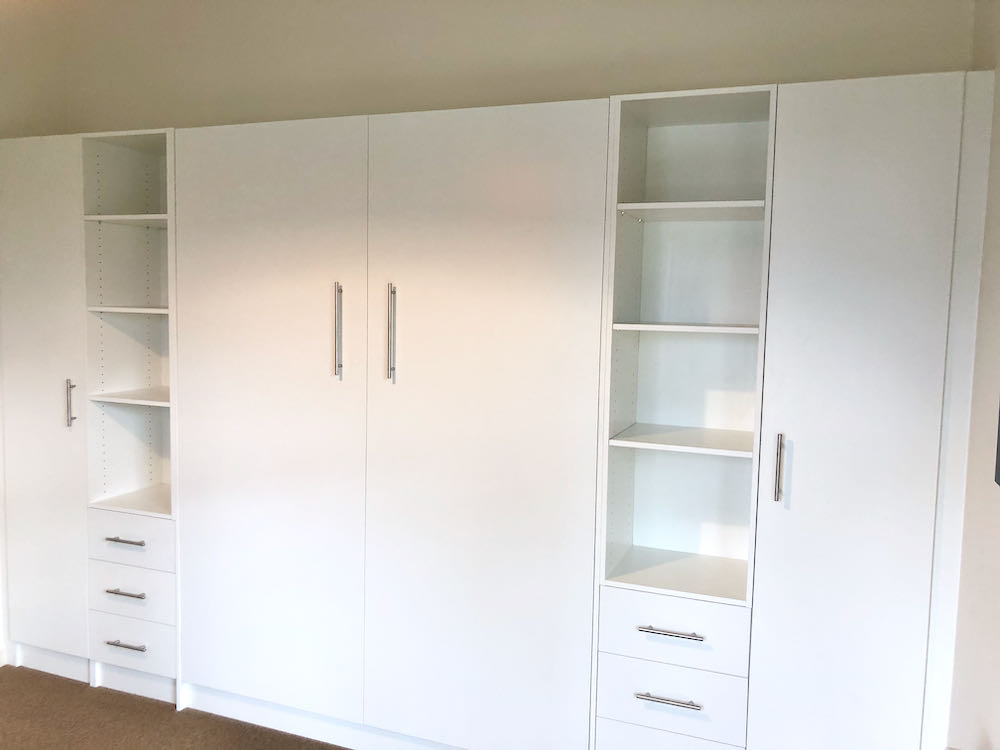 Wall bed closed with cupboards and shelves